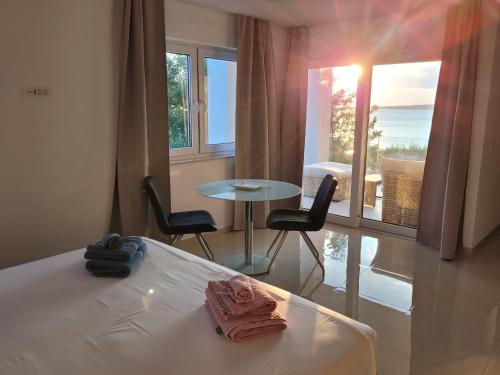 a room with a bed and a table with chairs at Aparthotel Dalmacija in Privlaka