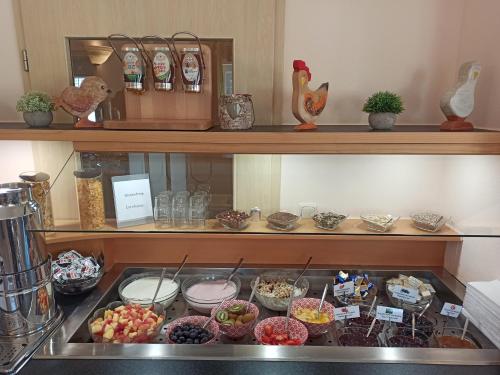 a kitchen with a bunch of food on a shelf at Hotel Nummerhof in Erding