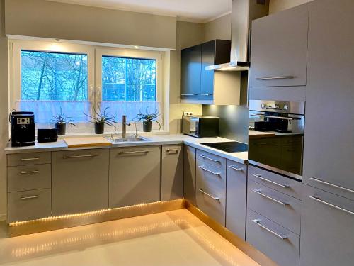 a kitchen with stainless steel cabinets and a sink at Yose Apartment - 160 m2 na wyłączność in Poznań