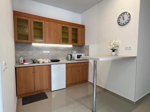 a kitchen with wooden cabinets and a clock on the wall at Madonna Apartments in Karlovy Vary