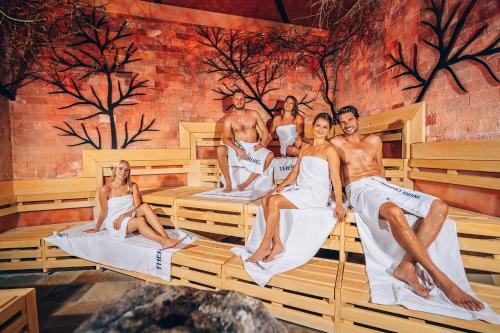a group of people sitting in a sauna at Hotel Nummerhof in Erding