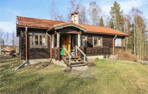 a small wooden house with a porch and a door at Amazing Home In Enviken With Lake View in Svärdsjö