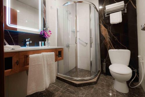 ein Bad mit einer Dusche, einem WC und einem Waschbecken in der Unterkunft Amman Inn Boutique Hotel in Amman