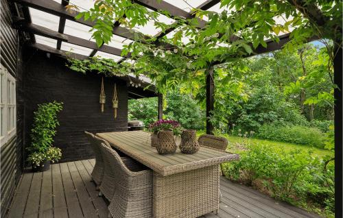 a table and chairs on a patio with a pergola at 4 Bedroom Amazing Home In Knebel in Knebel