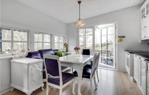 a dining room with a white table and blue chairs at 4 Bedroom Amazing Home In Knebel in Knebel