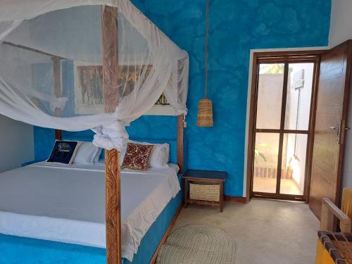 a bedroom with a canopy bed in a blue room at Villa Adelina Zanzibar in Zanzibar City
