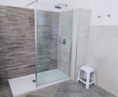a shower with a glass door next to a stool at Villa fronte mare in Levanto