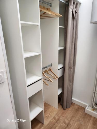 a walk in closet with white shelves at Charmant studio vue mer / parking / plage à 200m in Bastia