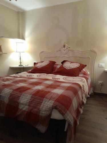a bedroom with a red and white bed with red pillows at Casa MARIA in Limone Piemonte