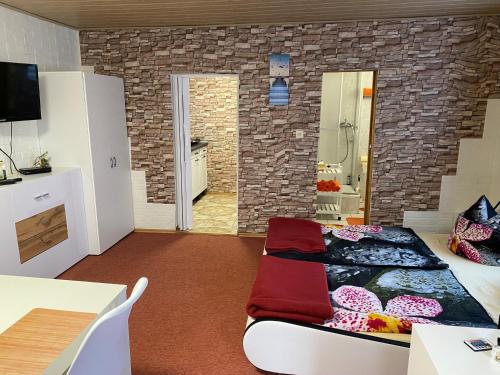 um quarto com uma cama num quarto com uma parede de tijolos em Ferienwohung Marina em Großwoltersdorf