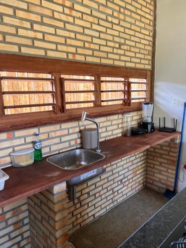 eine Küchentheke mit einem Waschbecken in einer Backsteinwand in der Unterkunft Bungalows Morro Do Chapeu Taiba in Taíba