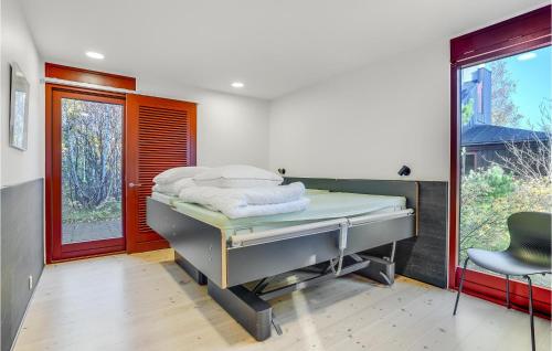ein Krankenhauszimmer mit einem Bett und einem Stuhl in der Unterkunft 2 Bedroom Gorgeous Home In Grenaa in Grenå