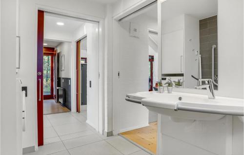 ein weißes Bad mit einem Waschbecken und einem Flur in der Unterkunft 2 Bedroom Gorgeous Home In Grenaa in Grenå