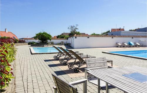 a row of lounge chairs and a swimming pool at 1 Bedroom Awesome Apartment In Gudhjem in Gudhjem