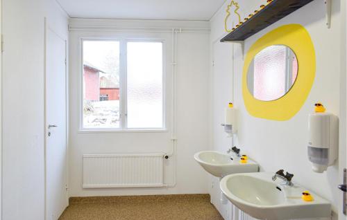 a white bathroom with two sinks and a window at Nice Home In Orrefors With Jacuzzi in Orrefors