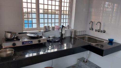 a kitchen with a counter top with a sink and a stove at JiNo Homestay in Khajurāho