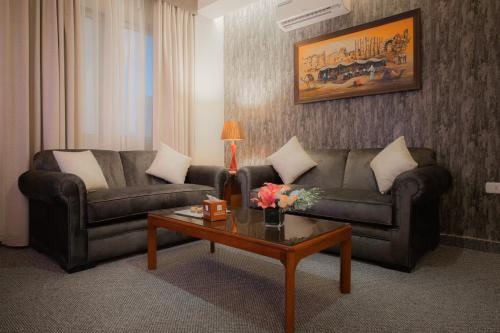a living room with a couch and a coffee table at Amman Inn Boutique Hotel in Amman