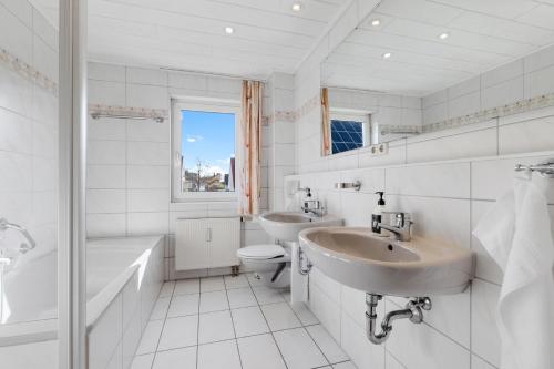 ein weißes Badezimmer mit zwei Waschbecken, einer Badewanne und einem WC in der Unterkunft Apartments Münchbach - near Europa-Park and Rulantica - 82qm - Balcony I Parking I Kitchen I WiFi in Rust