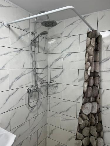 a bathroom with a shower with white marble tiles at CAZARE JASMINA in Corbu