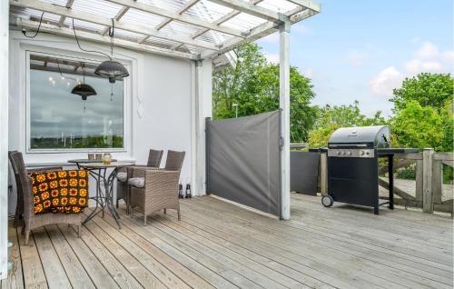 a patio with a grill and a table and chairs at Awesome Home In Havndal With Wifi in Havndal