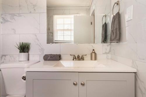 a white bathroom with a sink and a mirror at Updated home near Fort Jackson in Columbia