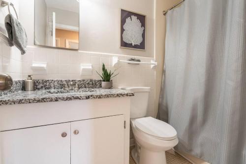 a white bathroom with a toilet and a shower at Updated home near Fort Jackson in Columbia