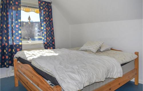 a bed with a wooden frame in a room with a window at Nice Home In Sölvesborg in Sölvesborg