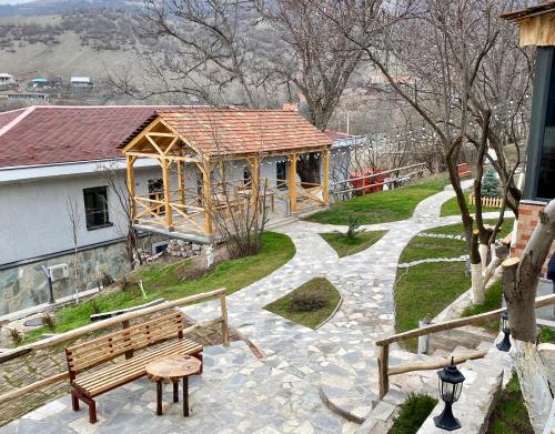 a wooden gazebo with a bench in a park at Madin Eco Hotel in Debed