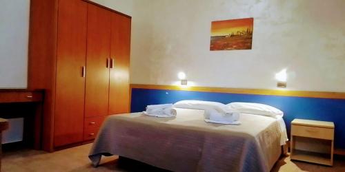 a bedroom with a bed with two towels on it at Residence Igea in Rimini