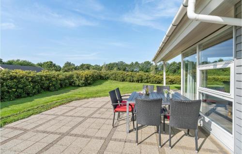 a patio with a table and chairs on a patio at Nice Home In Hovborg With Sauna in Hovborg