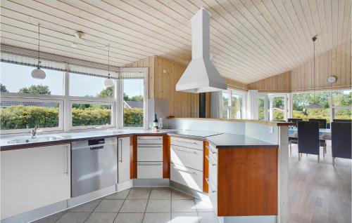 a kitchen with wooden ceilings and a large kitchen with white appliances at Nice Home In Hovborg With Sauna in Hovborg