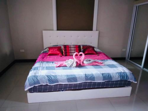 a bedroom with a bed with two pink ribbon at Preme Apartment @maejo in Ban Pa Lan