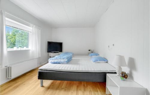 a white bedroom with a bed and a window at Awesome Home In Rødby With Kitchen in Rødby