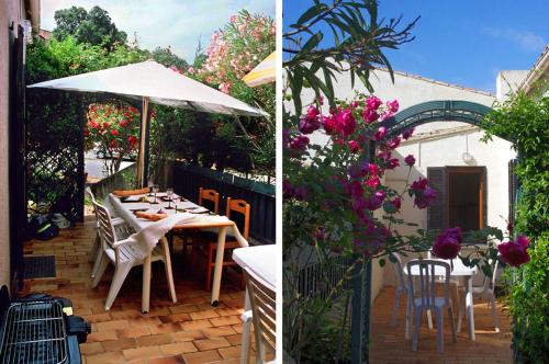 - une terrasse avec une table, un parasol et des fleurs dans l'établissement Maisonnette Paesolu Porticcio, à Porticcio