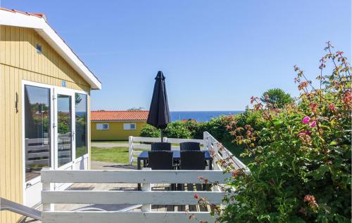 a patio with an umbrella and chairs and a table at Hus 55 B in Allinge