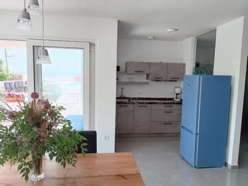 a kitchen with a blue refrigerator and a table at Aparthotel Dalmacija in Privlaka