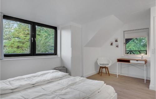 um quarto branco com uma cama, uma secretária e 2 janelas em Amazing Apartment In Blokhus With Wifi em Blokhus