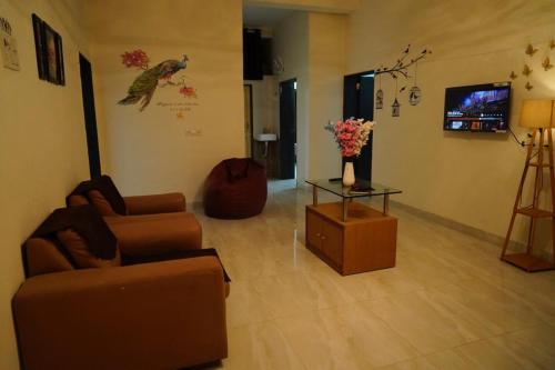 een woonkamer met 2 banken en een tafel met bloemen bij Elite stays in Pune