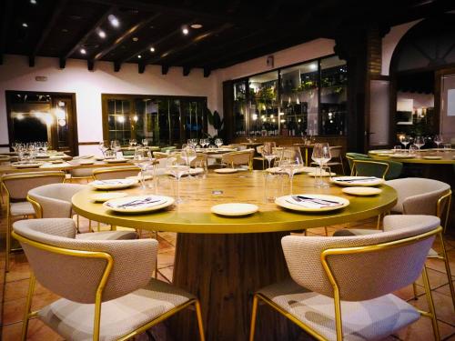 a restaurant with a large wooden table and chairs at Villa Xarahiz in Jaraiz de la Vera