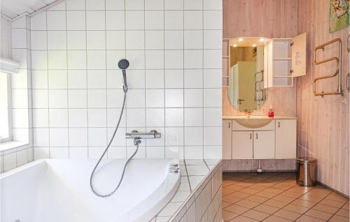 a bathroom with a bath tub and a sink at Stunning Home In Aakirkeby With Wifi in Vester Sømarken