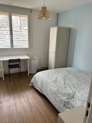 - une chambre avec un lit, un bureau et un réfrigérateur dans l'établissement Rénové, proche centre-ville et Arsenal, à Brest