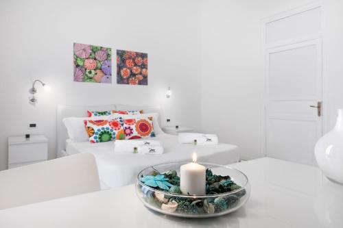 ein weißes Wohnzimmer mit einer Kerze auf dem Tisch in der Unterkunft Room & Breakfast Zero in Palermo