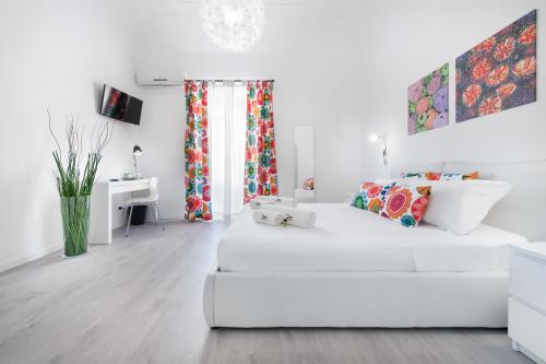 ein weißes Wohnzimmer mit einem weißen Sofa und einem Schreibtisch in der Unterkunft Room & Breakfast Zero in Palermo
