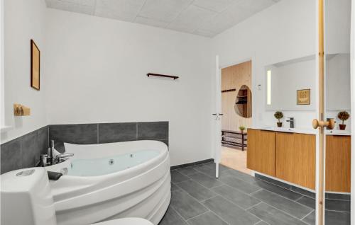 a bathroom with a white tub and a sink at Beautiful Home In Spttrup With Wifi in Lihme