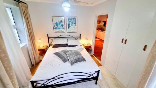 a bedroom with a black and white bed in a room at Crescent cottage in Knysna