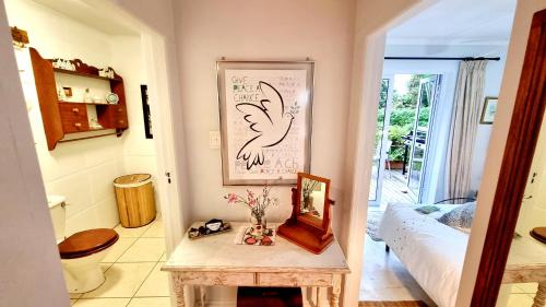 a room with a table and a bed and a mirror at Crescent cottage in Knysna