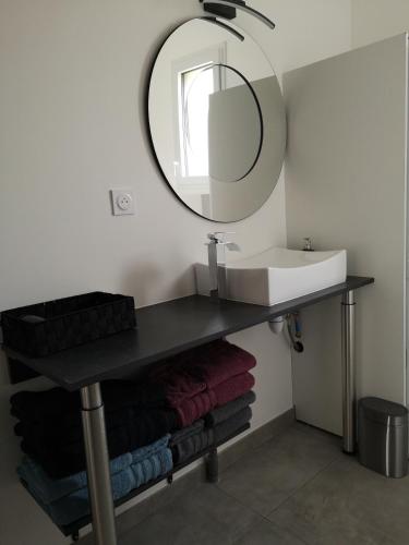 a bathroom with a sink and a mirror and towels at A DEUX PAS DE BEAUVAL - LE GITE in Saint-Aignan