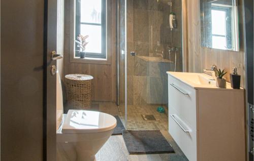 a bathroom with a toilet and a shower and a sink at 4 Bedroom Lovely Home In stby in Østby