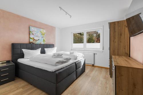 ein Schlafzimmer mit einem großen Bett und einem TV in der Unterkunft Apartments Münchbach - near Europa-Park and Rulantica - Parking I Kitchen I WiFi in Rust