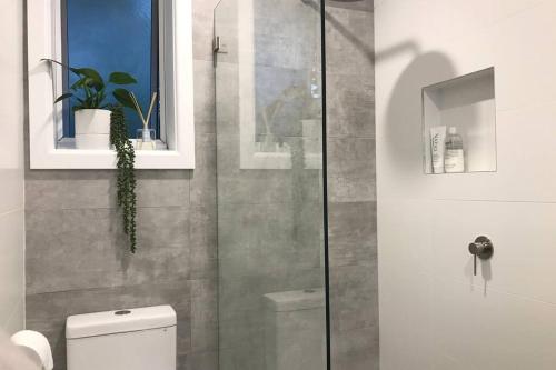 a bathroom with a toilet and a glass shower at Travellers Retreat Bayview in Bay View